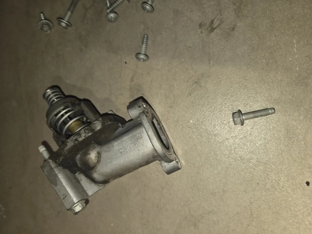 Housing and thermostat off the car, gasket face ready to be cleaned before it goes back — Moreno Valley, CA