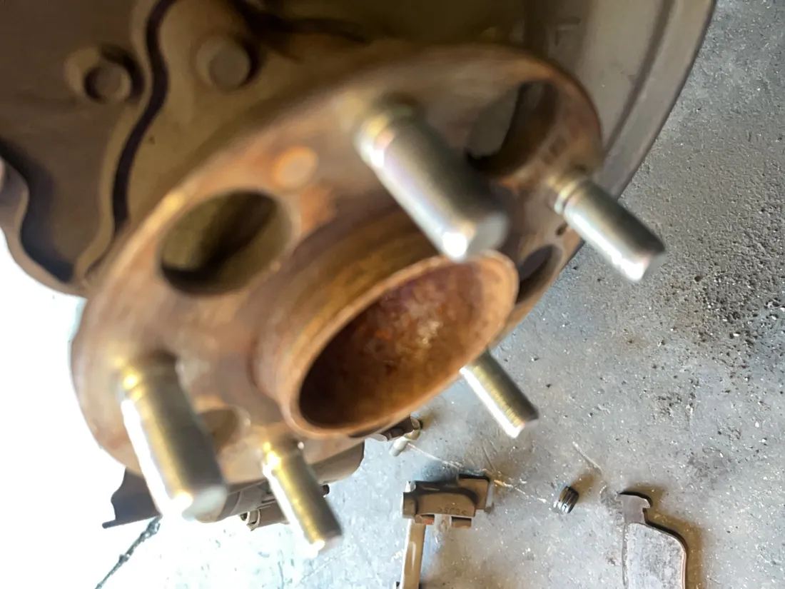 Hub and studs cleaned down to bare metal so the new rotor seats flat instead of running out — Hemet, CA